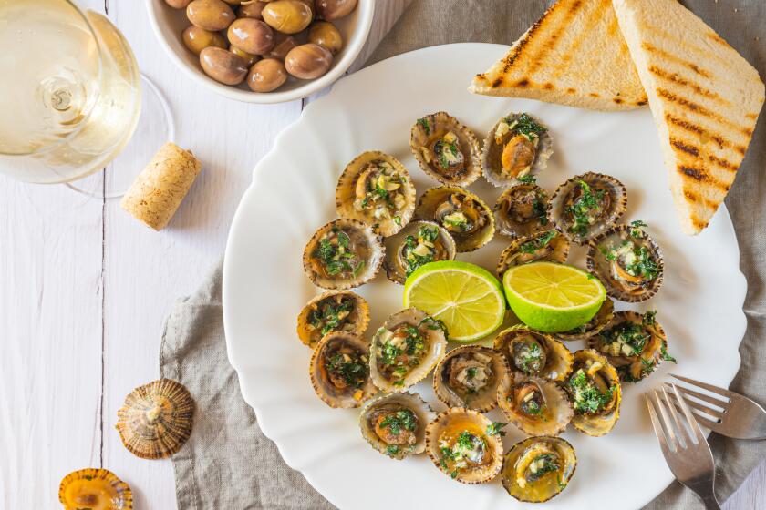 Patella, Limpets served with lime, olives and glass of white whine - traditional seafood of Tenerife and Madeira Islands.