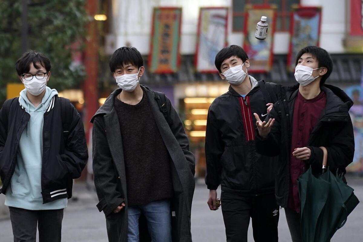 Peatones con mascarillas, el miércoles 26 de febrero de 2020, en Tokio. (AP Foto/Eugene Hoshiko) ** Usable by HOY, ELSENT and SD Only **