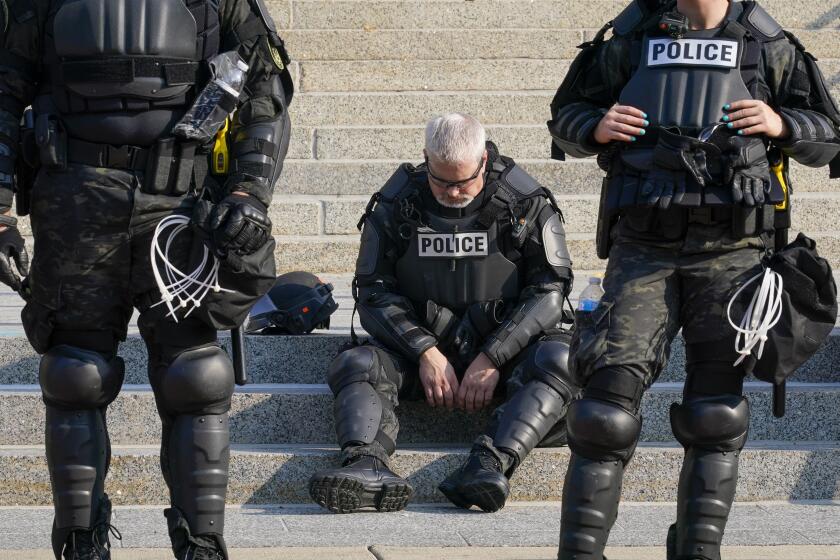 Police in riot gear outside the Kenosha (Wis.) County Court House on Monday.