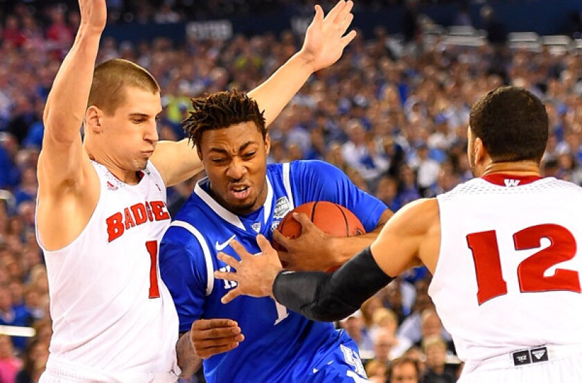 Kentucky forward James Young drives between Wisconsin's Ben Brust (1) and Traevon Jackson (12) in the first half Saturday night.