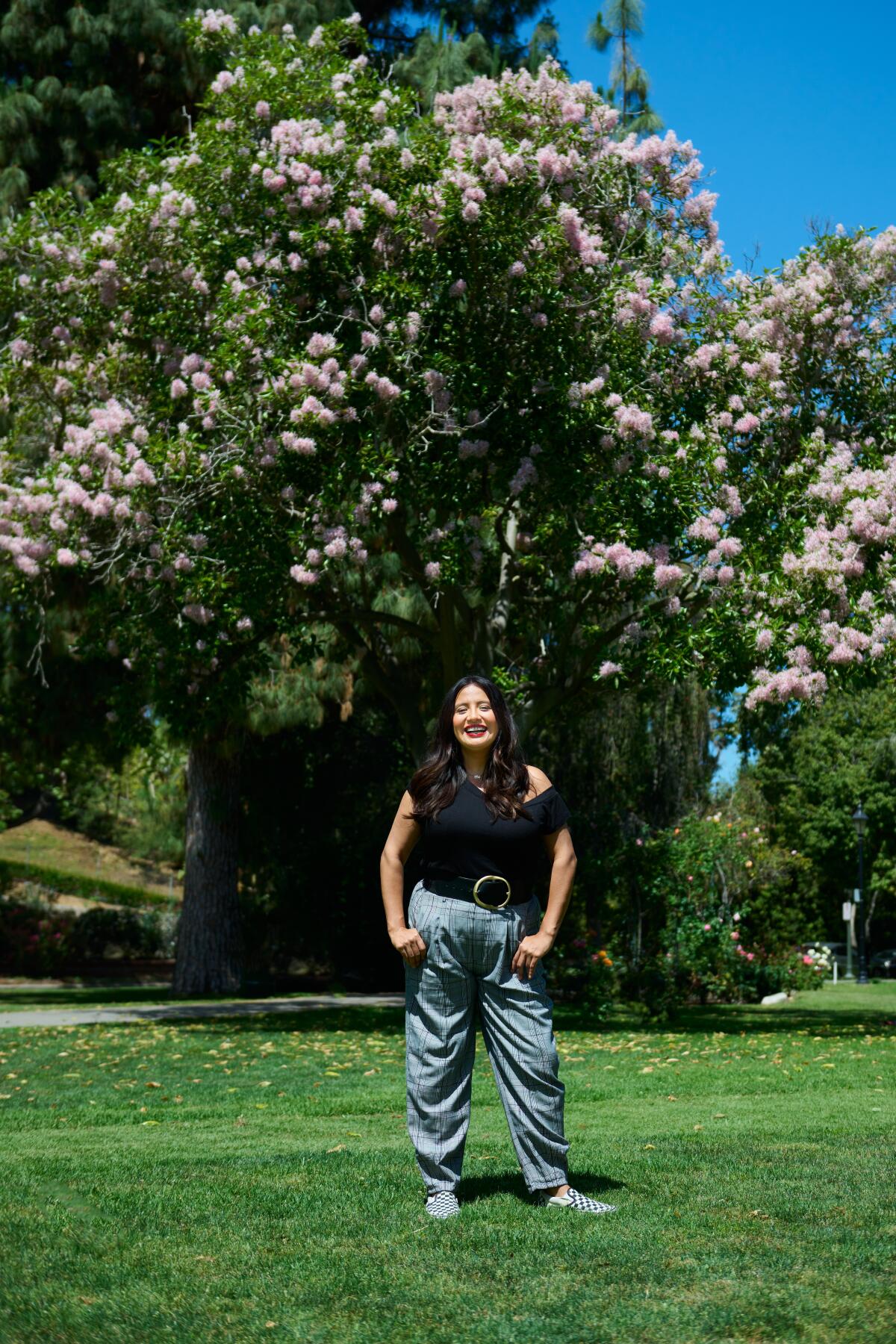 Cristela Alonzo standing in front of a tree at a park. 