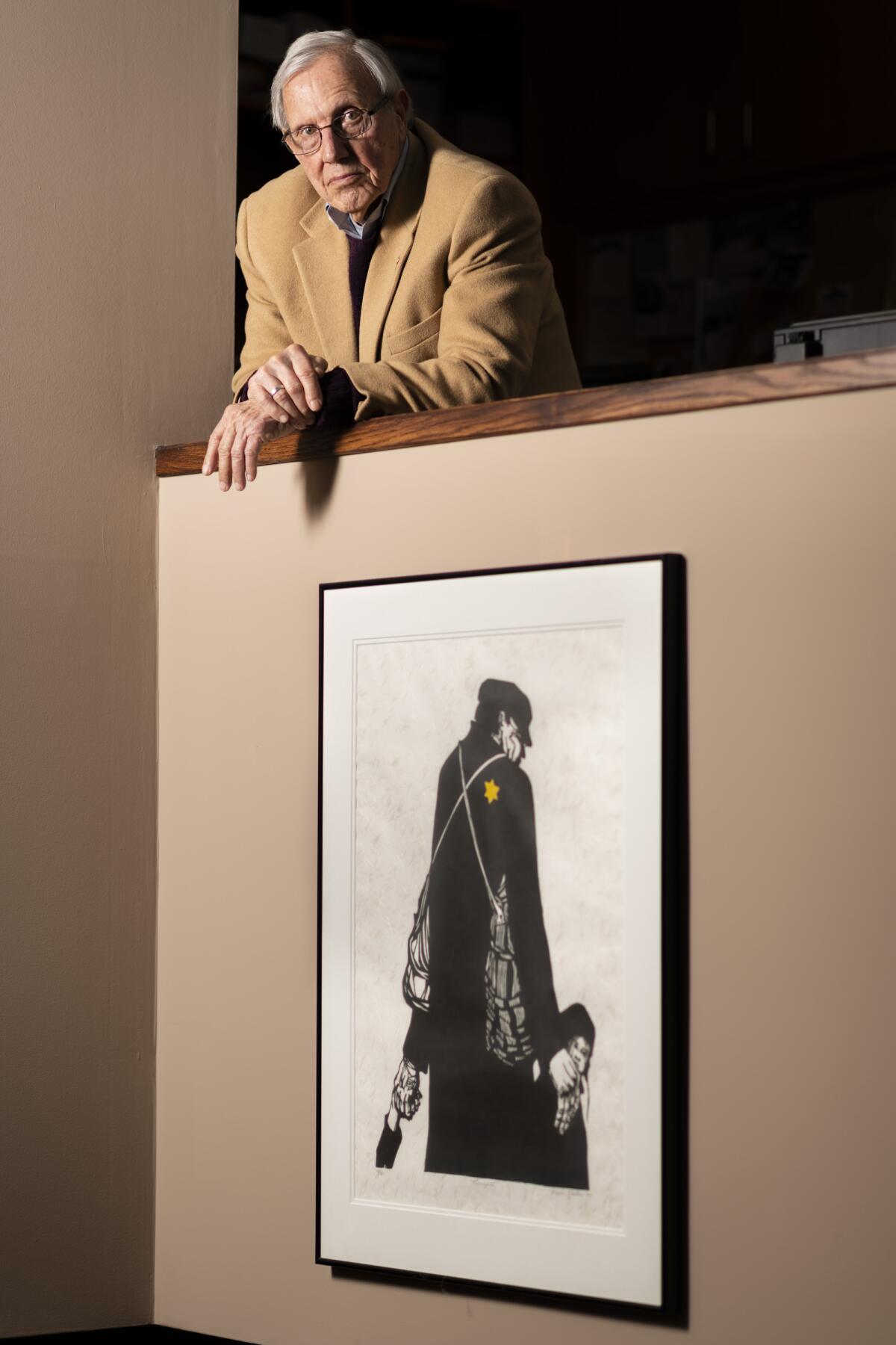 Steven Hess, 83, poses for a portrait above a Holocaust painting.