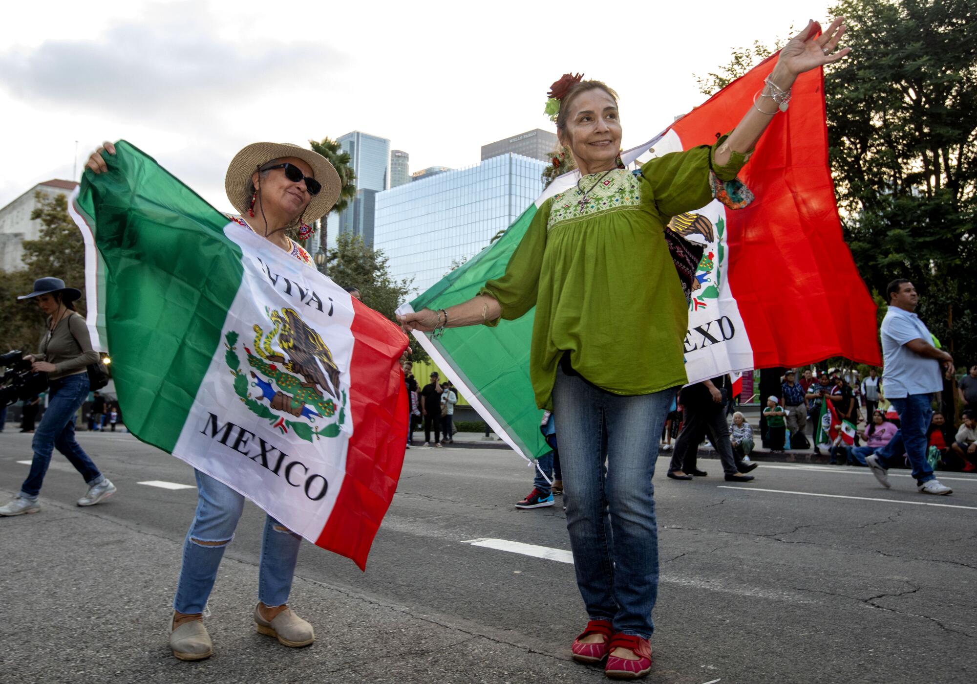 Two women dancing with Mexican flags