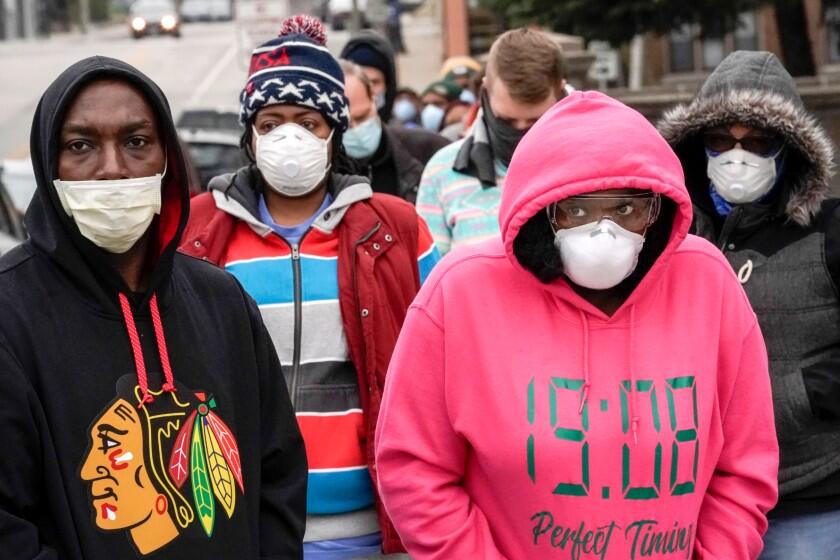Voters masked against the coronavirus line up in Milwaukee on Tuesday.