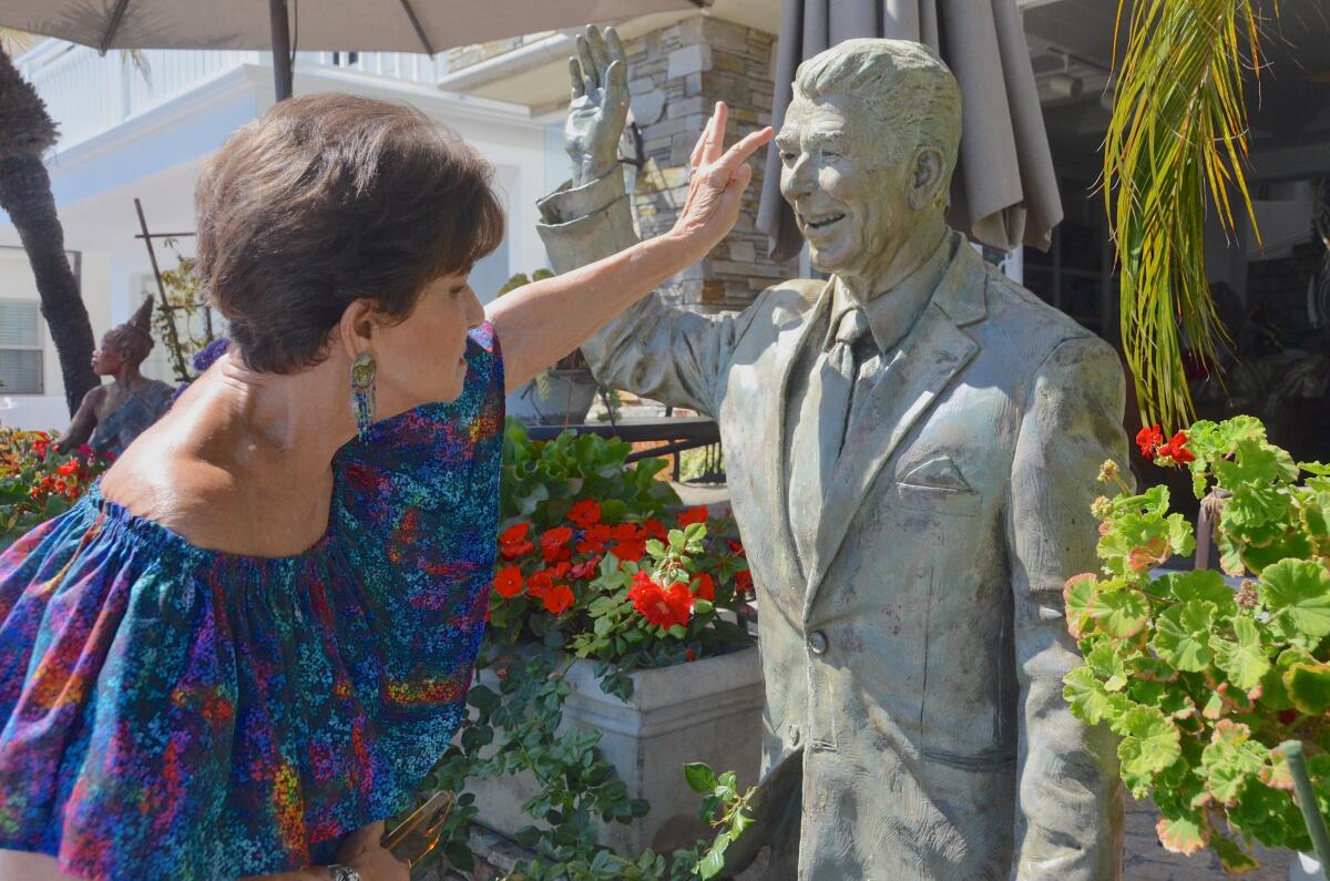 Miriam Baker points out damage done to Ronald Reagan bronze sculpture.