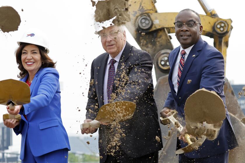 FILE - New York Gov. Kathy Hochul, left, Buffalo Bills owner Terry Pegula and Buffalo Mayor Byron Brown, right, participate in the groundbreaking ceremony at the site of the new Bills Stadium in Orchard Park, N.Y., June 5, 2023. Terry and Kim Pegula are exploring the possibility of selling a non-controlling, minority interest in the franchise, the team announced Friday, April 19, 2024. The prospect of selling shares of the Bills comes at a time the franchise is facing a cash crunch with rising construction costs of the team’s new stadium. (AP Photo/Jeffrey T. Barnes, File)