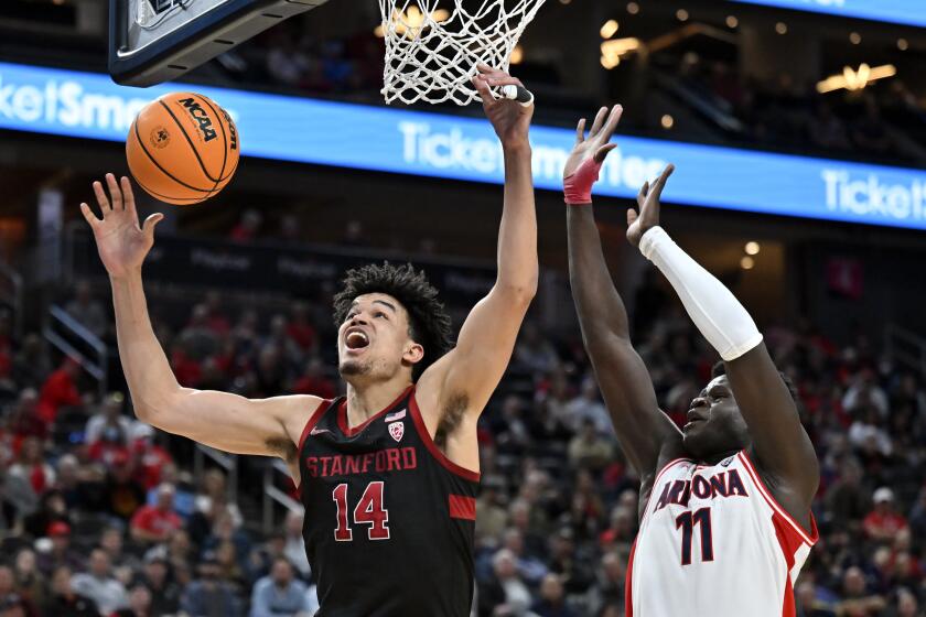 Stanford forward Spencer Jones (14) loses the ball on a shot attempt against Arizona center Oumar Ballo (11) during the second half of an NCAA college basketball game in the quarterfinals of the Pac-12 men's tournament Thursday, March 9, 2023, in Las Vegas. (AP Photo/David Becker)