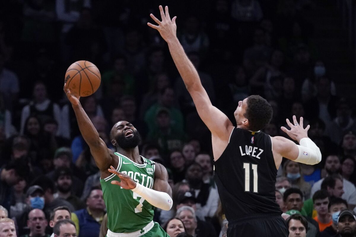 Boston Celtics guard Jaylen Brown, left, shoots while pressured by Milwaukee Bucks center Brook Lopez (11) during the first half of Game 2 of an Eastern Conference semifinal in the NBA basketball playoffs Tuesday, May 3, 2022, in Boston. (AP Photo/Charles Krupa)