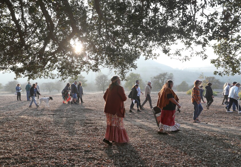 Guests walk under the canopy of the Mother Tree at the Putuidem Village in San Juan Capistrano.