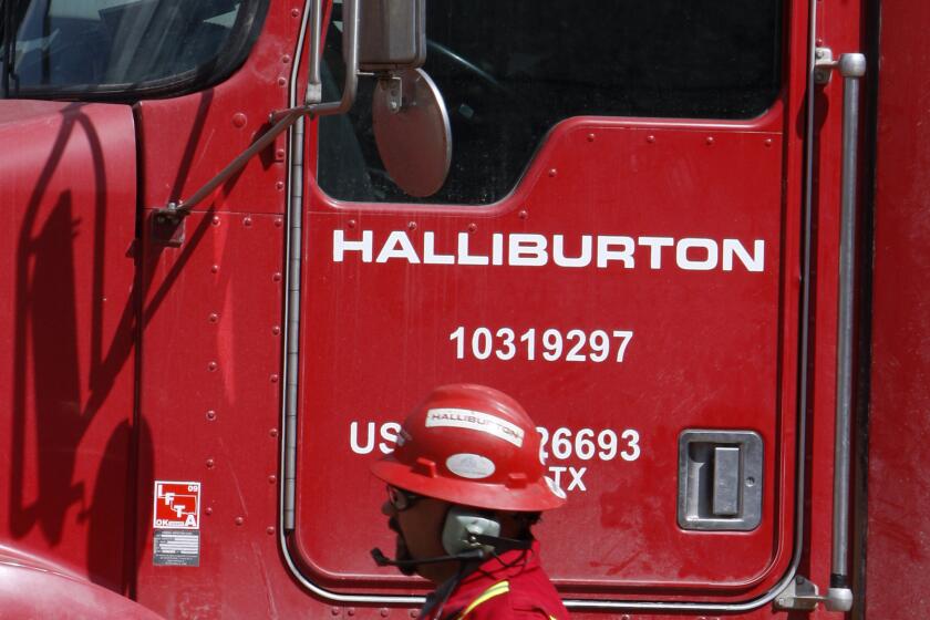 An unidentified worker passes a truck owned by Halliburton in Rulison, Colo., on April 15, 2009.
