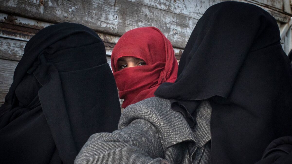 Women fleeing fighting in Islamic State's last holdout in Syria last month look out from the back of a truck.