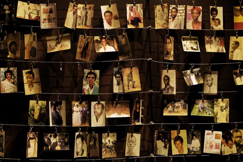 FILE - In this Friday, April 5, 2019 file photo, family photographs of some of those who died hang on display in an exhibition at the Kigali Genocide Memorial centre in the capital Kigali, Rwanda. A report commissioned by the Rwandan government due to be made public on Monday, April 19, 2021 concludes that the French government bears "significant" responsibility for "enabling a foreseeable genocide" that left more than 800,000 dead in 1994 and that that France "did nothing to stop" the massacres. (AP Photo/Ben Curtis, File)