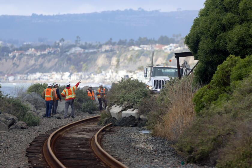 SAN CLEMENTE CA JANUARY 25, 2024 - Workers in San Clemente continue to clear the tracks following a landslide in San Clemente that occurred on Wednesday, Jan. 24. Passenger rail service between the Laguna Niguel/Mission Viejo and Oceanside stations remained suspended due to a landslide that again sent boulders and debris onto the tracks and damaged the Mariposa Trail Bridge in San Clemente. (Allen J. Schaben / Los Angeles Times)