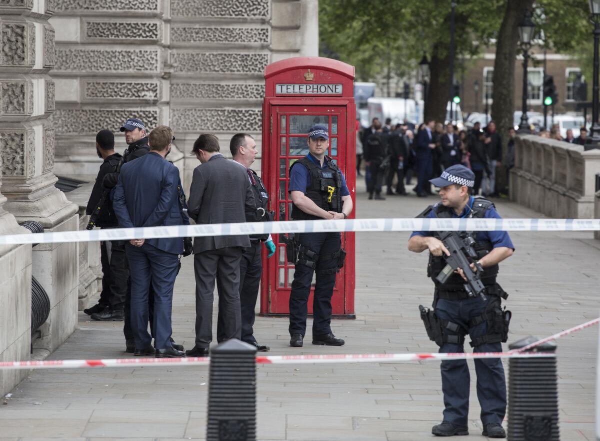 A man is detained by police officers April 27 near Downing Street in London.