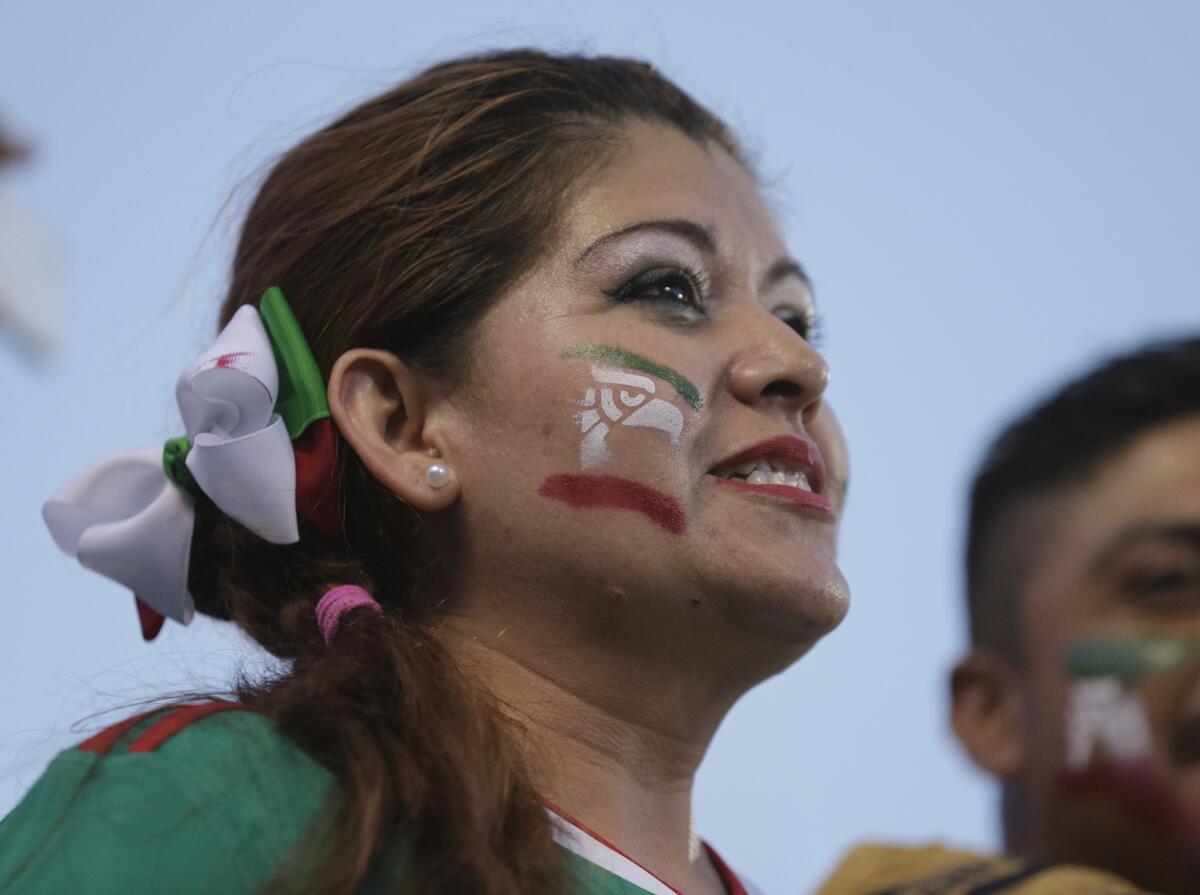 A Mexico fan cheers her team during the first half of a CONCACAF Gold Cup soccer match against Trinidad & Tobago in Charlotte, N.C., Wednesday, July 15, 2015. (AP Photo/Chuck Burton)