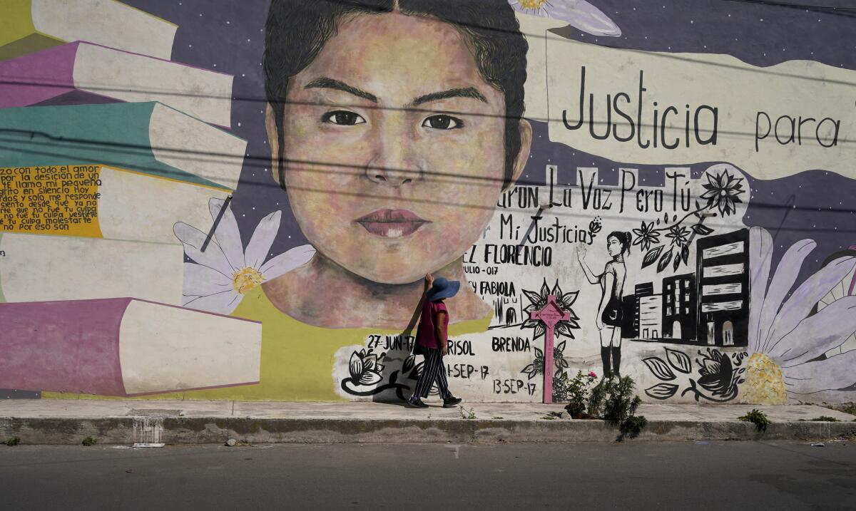 Diana Velazquez's mother touches a mural of her daughter at the site where her body was found.