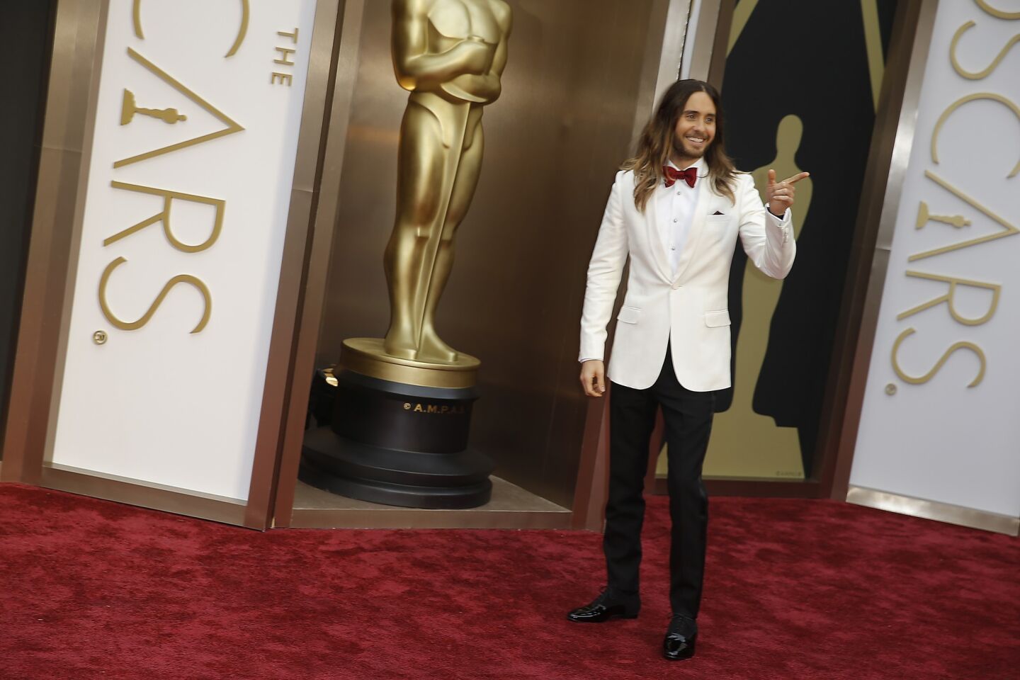 Jared Leto in an ivory-colored shawl collar tuxedo, burgundy bow tie and hint of a pocket square.