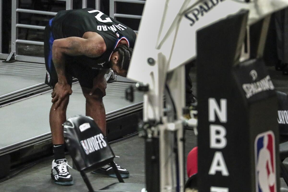 Clippers forward Kawhi Leonard (2) bends over in pain after hurting his right leg in Game 4 of the Jazz series.