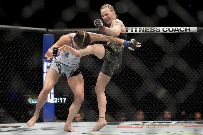 Valentina Shevchenko, right, kicks Lauren Murphy during a women's flyweight mixed martial arts title bout at UFC 266, Saturday, Sept. 25, 2021, in Las Vegas. (AP Photo/John Locher)