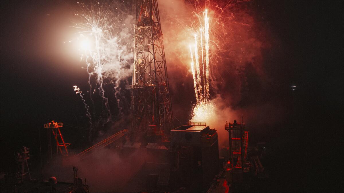 An aerial view of fireworks by a collapsing tower. 