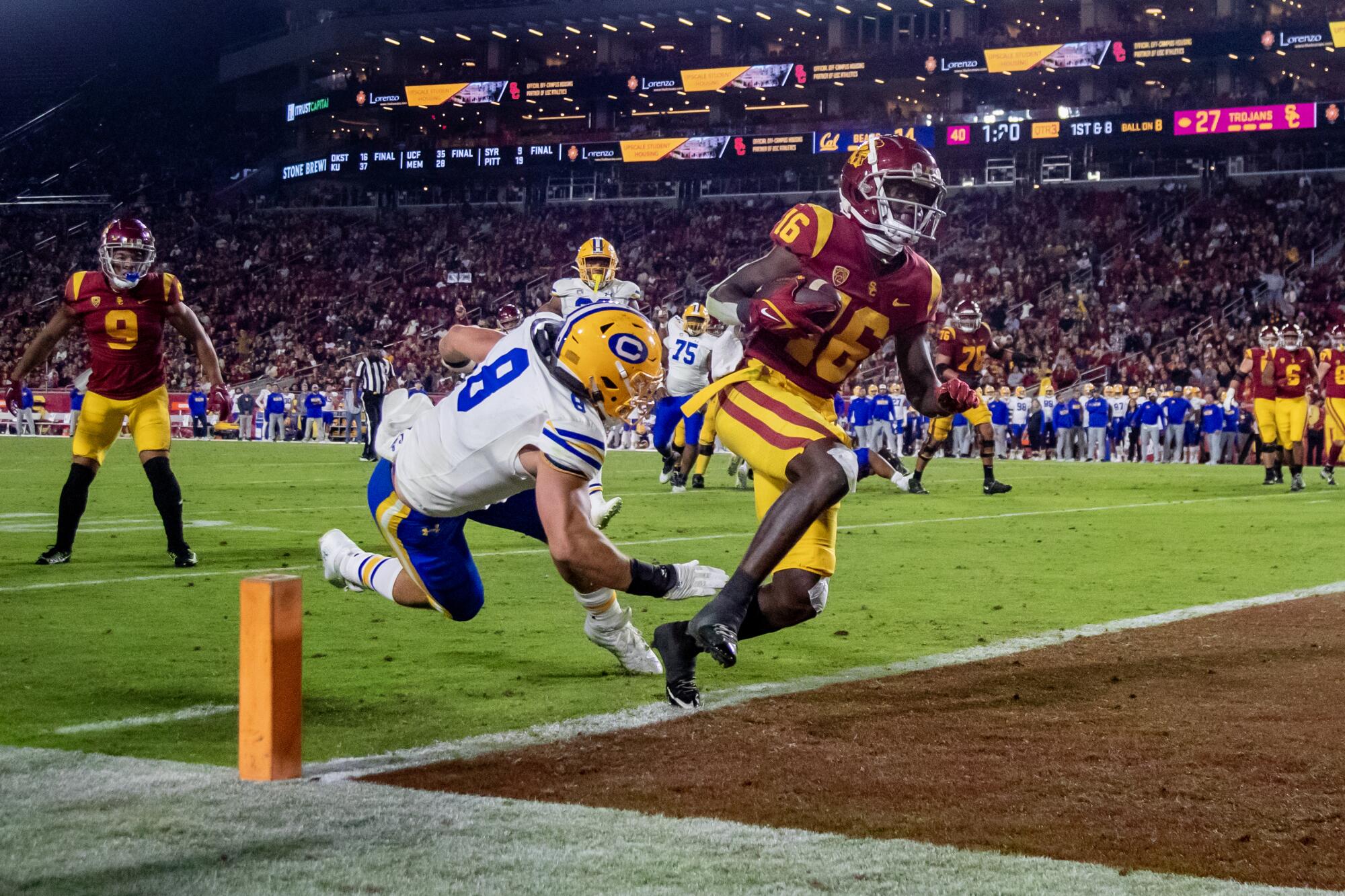USC wide receiver Tahj Washington scampers into the end zone in front of California linebacker Jackson Sirmon.