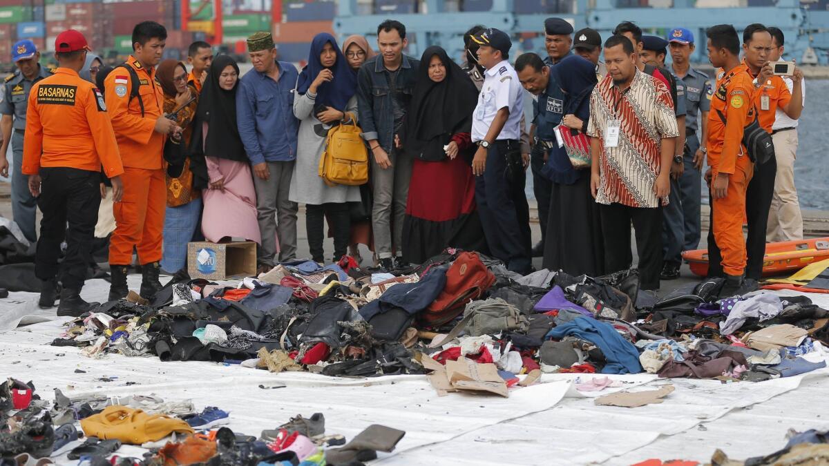 Relatives of passengers of the crashed Lion Air jet check personal belongings retrieved from the waters where the airplane crashed, at Tanjung Priok Port in Jakarta, Indonesia, on Oct. 31.