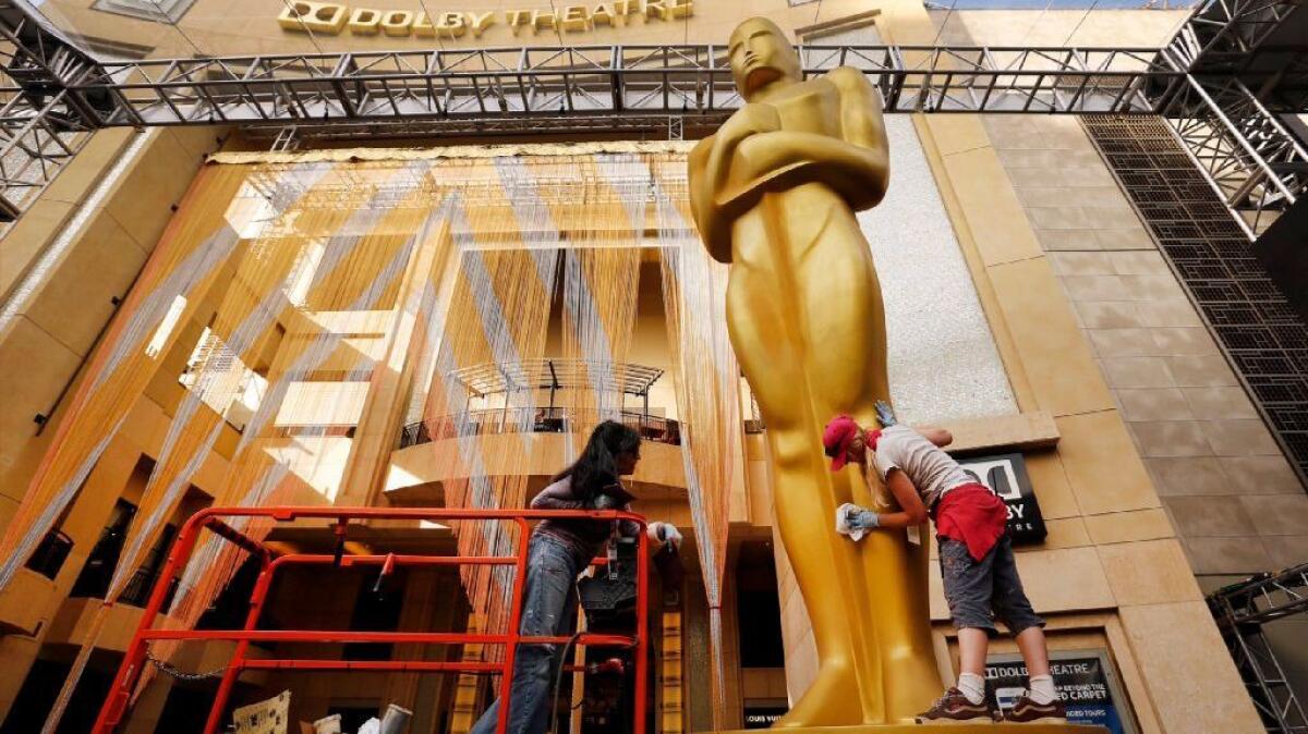 Workers touch up a giant Oscar statue on the red carpet entrance at the Dolby Theatre in Hollywood on February 23, 2016.