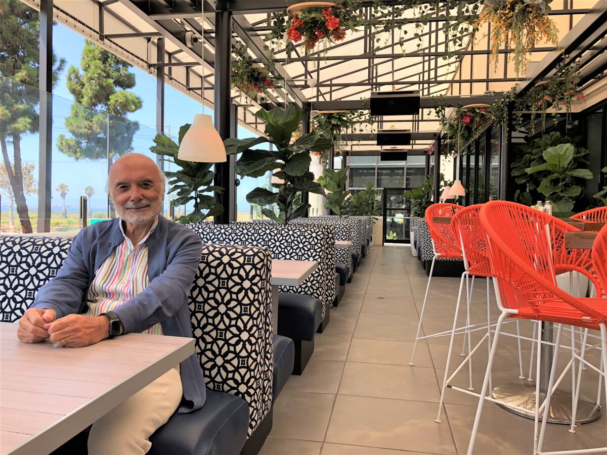 Sami Ladeki seated in his new greenhouse-style Sammy's Restaurant & Bar location in Chula Vista.