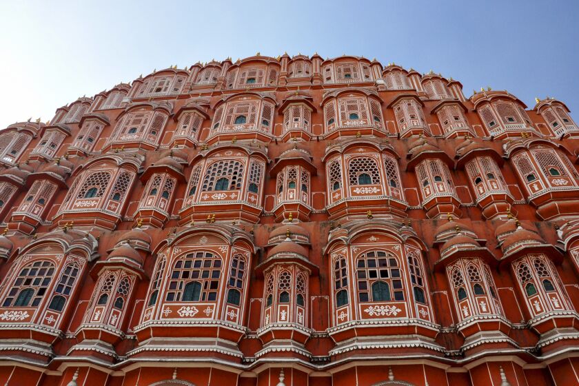 Openings in the lattice windows of the Hawa Mahal allow visitors to observe a busy street below just as ladies in purdah once did inside the "Pink City" in Jaipur, India.