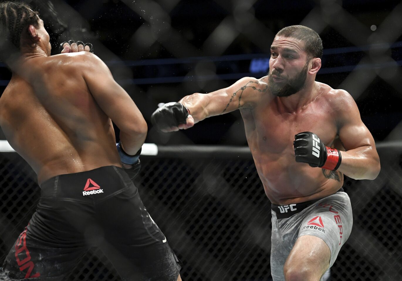 Jimmie Rivera, right, throws a punch at John Dodson during their bantamweight mixed martial arts bout at UFC 228 on Saturday, Sept. 8, 2018, in Dallas. (AP Photo/Jeffrey McWhorter)