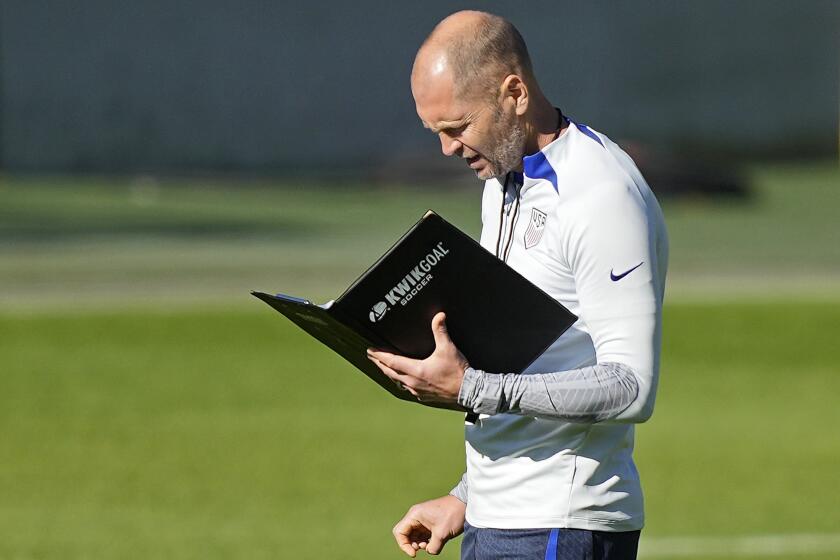 FILE - US head coach Gregg Berhalter reads a book during a training session of the US soccer team in Cologne, Germany, prior to a friendly match against Japan, Thursday, Sept. 22, 2022. (AP Photo/Martin Meissner, File)