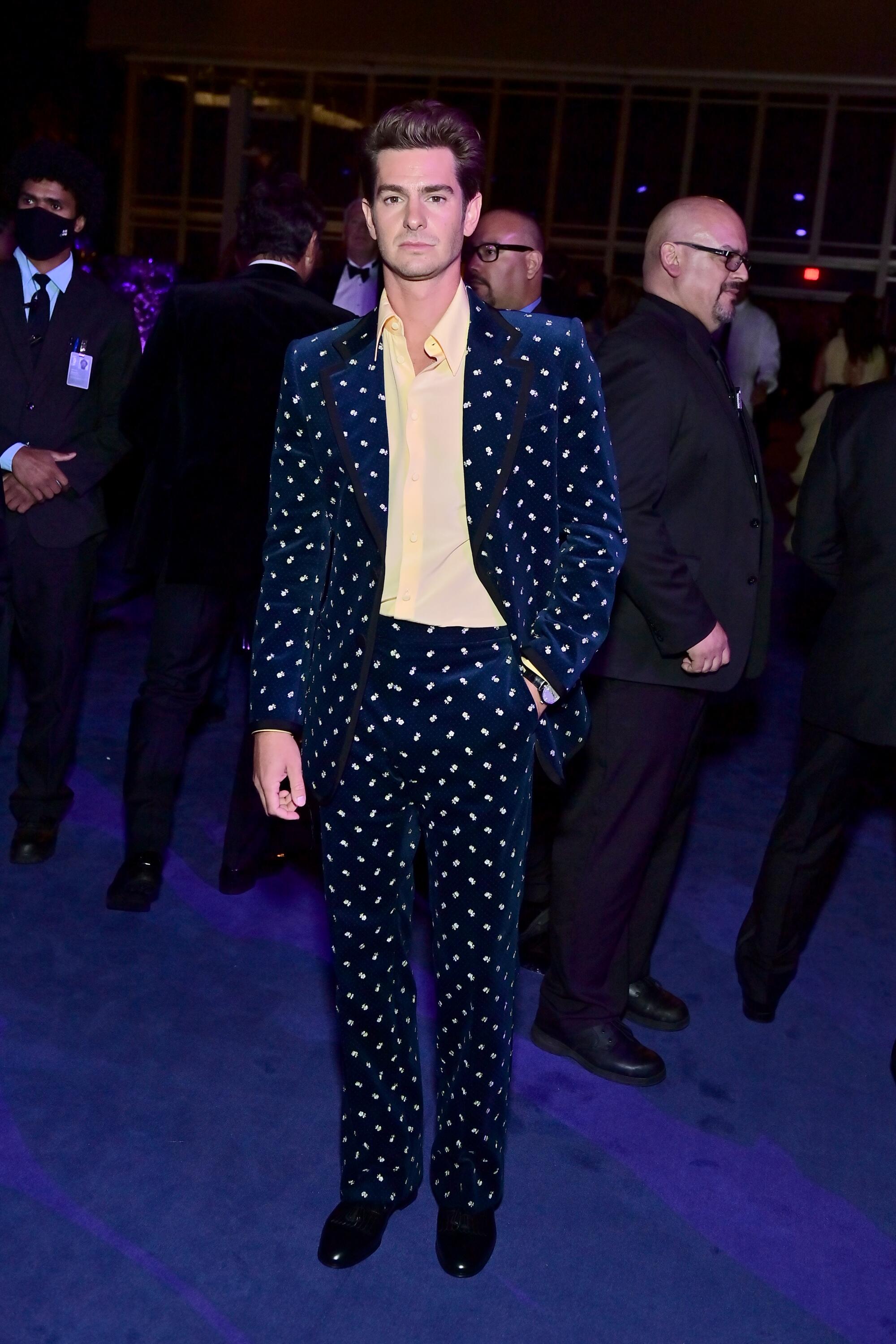 Andrew Garfield in a dark patterned suit.