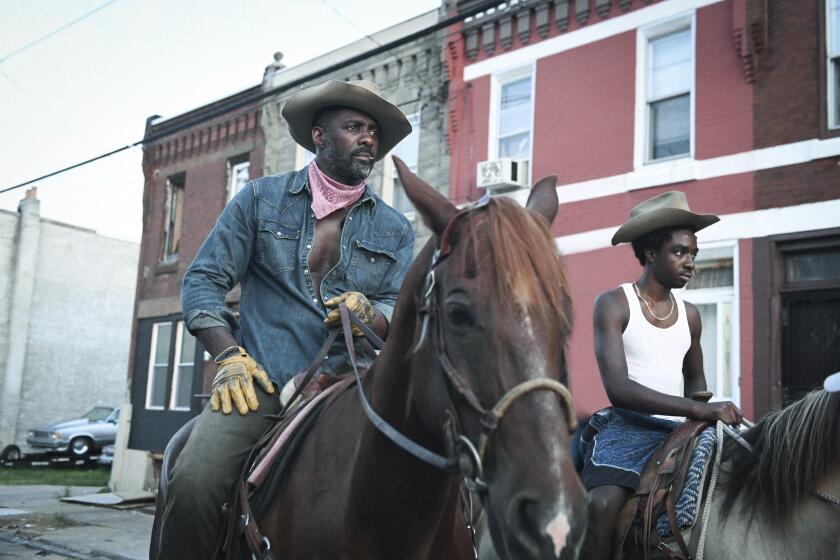 Esta imagen proporcionada por Netflix Idris Elba, izquierda, y Caleb McLaughlin en una escena de la película "Concrete Cowboy" que se estrena el 2 de abril en Netflix. (Netflix via AP)