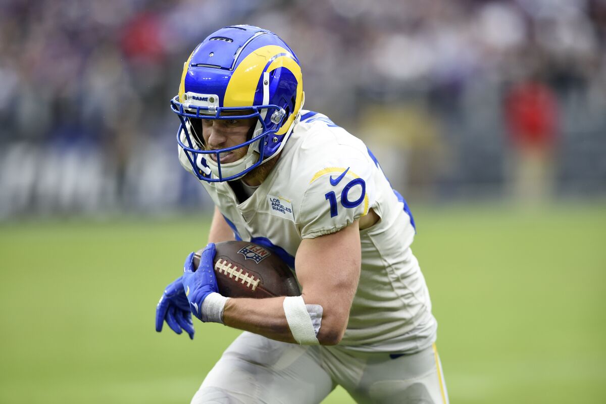 Los Angeles Rams wide receiver Cooper Kupp runs with the ball after making a catch against the Baltimore Ravens during the second half of an NFL football game, Sunday, Jan. 2, 2022, in Baltimore. On the play, Kupp broke the Rams' franchise single season record for most receiving yards after surpassing Isaac Bruce's 1,781 yards set in 1995. (AP Photo/Gail Burton)