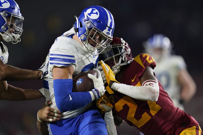 BYU tight end Dallin Holker (32) is tackle day Southern California safety Calen Bullock (27) during the second half of an NCAA college football game in Los Angeles, Saturday, Nov. 27, 2021. (AP Photo/Ashley Landis)