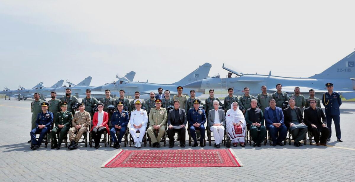 In this photo released by Pakistan's Press Information Department, Prime Minister Imran Khan, center in seated, top military officials, Chinese military officials, Chinese diplomates and Pakistan Air Force pilots pose for photograph in front of Chinese-built J-10C fighter jets during a ceremony in Minhas Base near Islamabad, Pakistan, Friday, March 11, 2022. Pakistan's air force officially inducted its first batch of Chinese-built J-10C fighter jets on Friday, holding a ceremony with officials from both sides in Islamabad. (Press Information Department via AP)