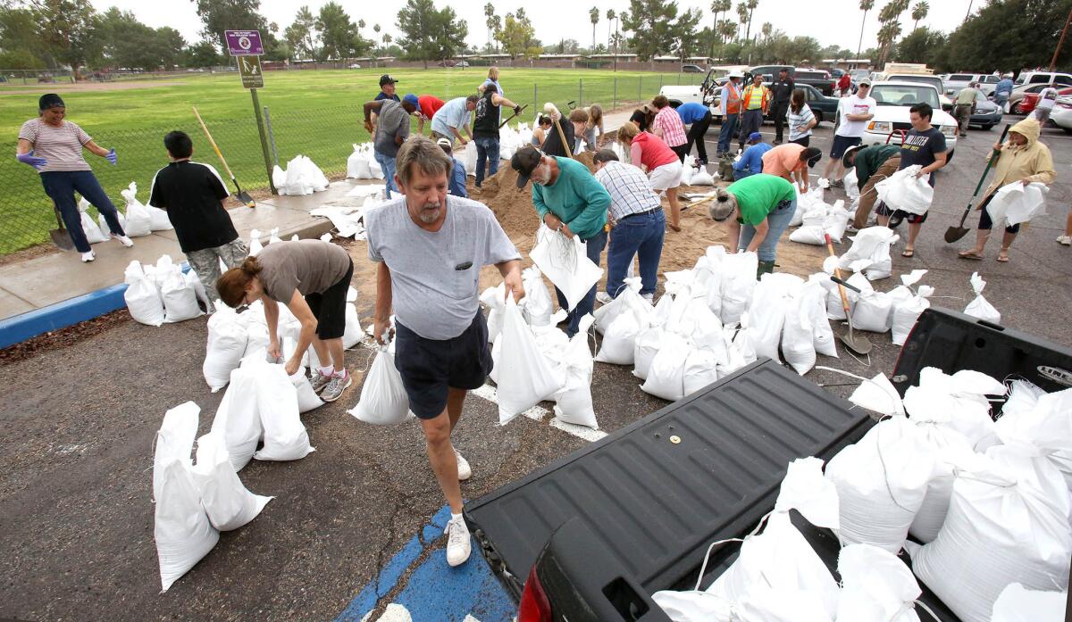 Barton Morse carries sandbags to his truck to deliver to a friend as a storm makes its way into Tucson.