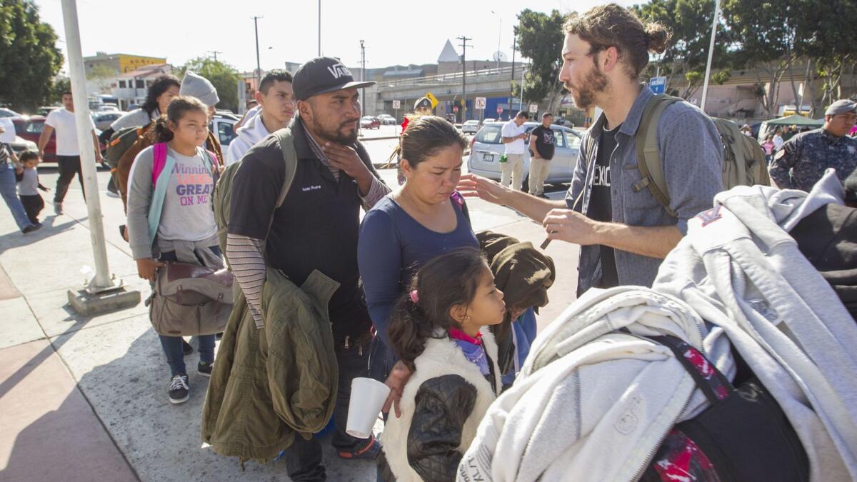 Alex Mensing of Pueblo sin Frontiers, rear, in early May takes a head count of a group of about 48 Central American refugees lined up to enter the US on Thursday morning, behind another group of 23 that had already presented themselves to immigration officials.