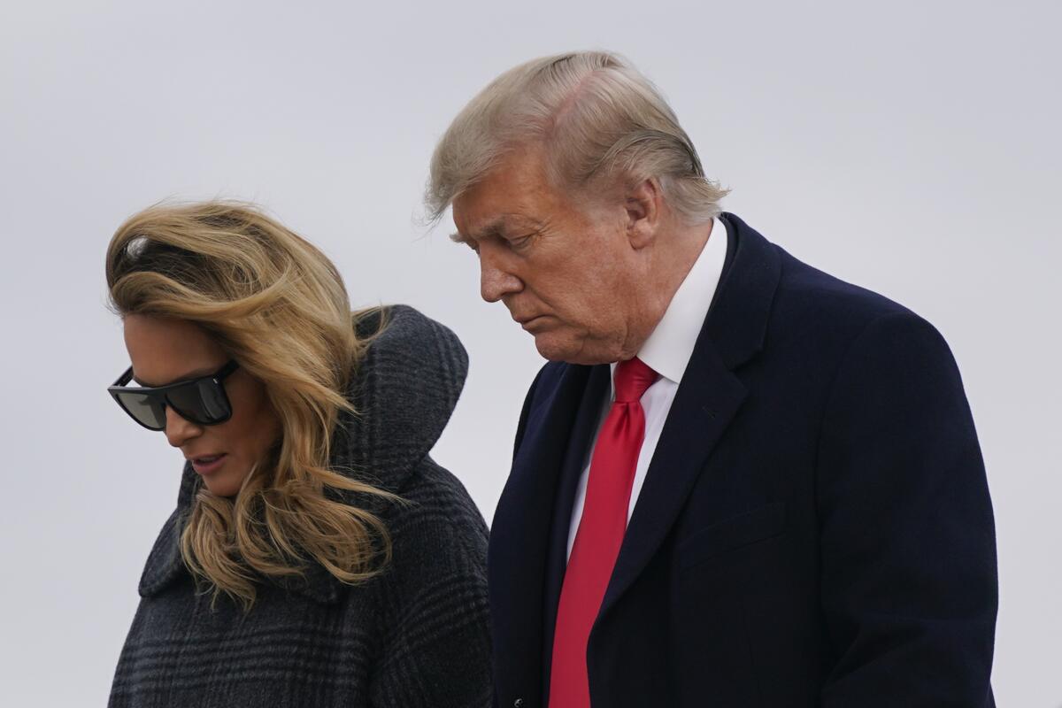 Donald Trump walks alongside Melania Trump. 