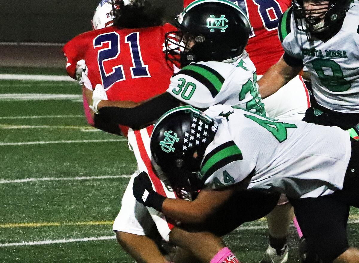 Costa Mesa's Darwin Palma (30) and Louis Arreola (44) tackle Bolsa Grande's Anthony Bell (21) in a Tango League game.