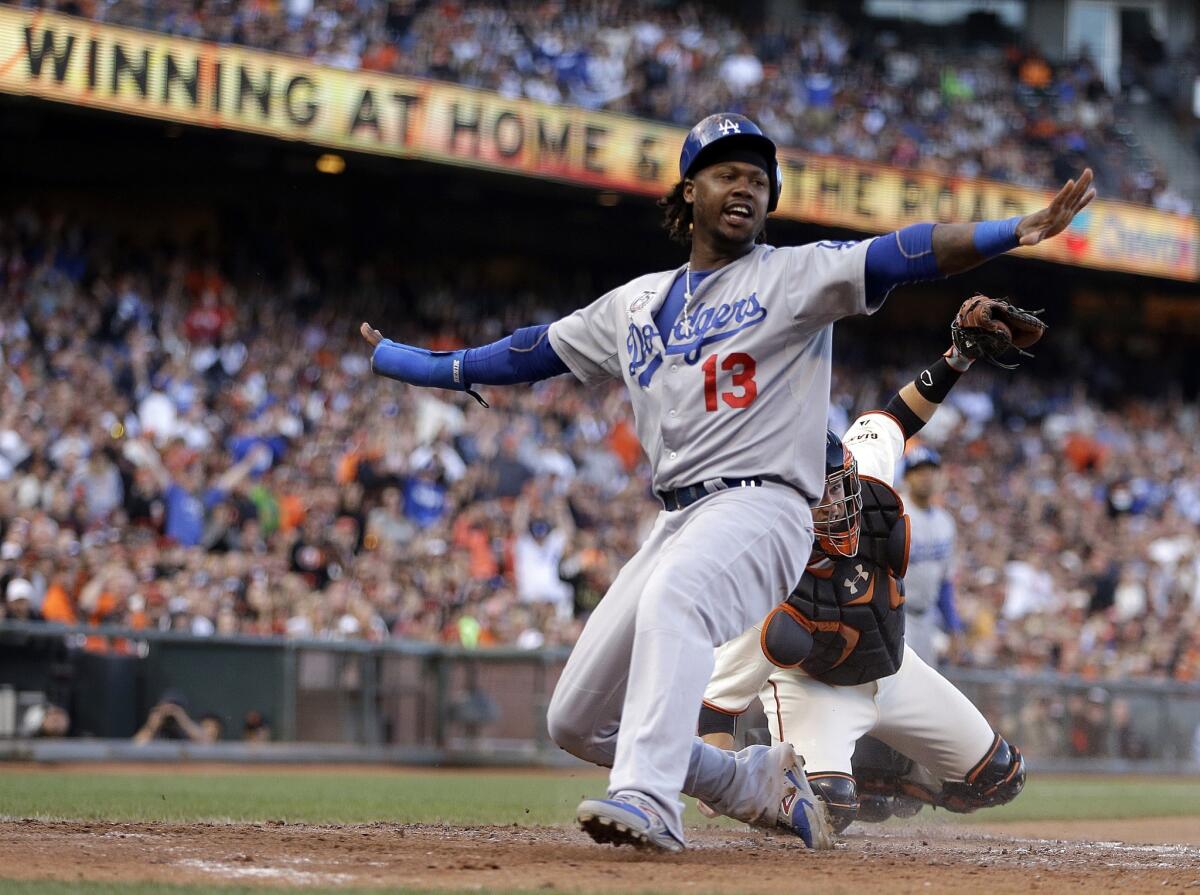 Hanley Ramirez signals that he's safe after scoring a run in front of Giants catcher Buster Posey in the fifth inning of a game on July 27.
