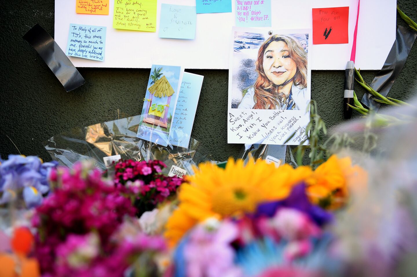 A portrait of Melyda Corado, who was shot and killed Saturday, is pinned to a memorial outside Trader Joe's in Silver Lake.
