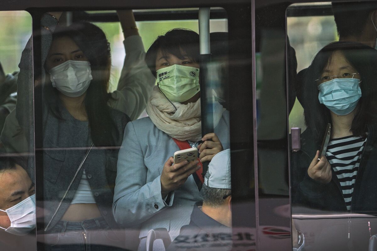 Commuters wear masks on a bus in Beijing