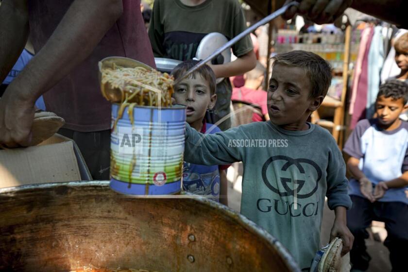 Un ni?o desplazado se encuentra en la fila para la distribución de alimentos en Deir al-Balah, Franja de Gaza, el jueves 17 de octubre de 2024. (Foto AP/Abdel Kareem Hana)
