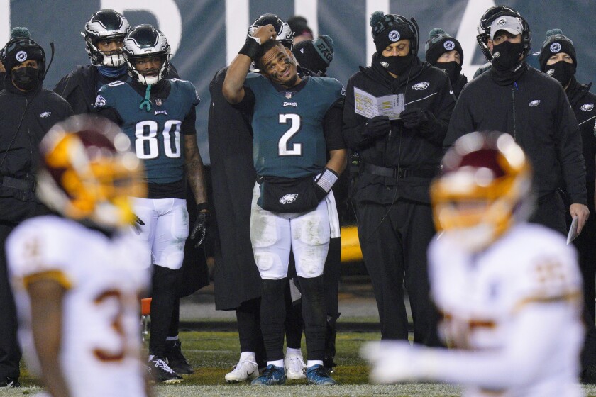 Philadelphia Eagles' Jalen Hurts scratches his head on the sideline during the second half of an NFL football game against the Washington Football Team, Sunday, Jan. 3, 2021, in Philadelphia. (AP Photo/Chris Szagola)