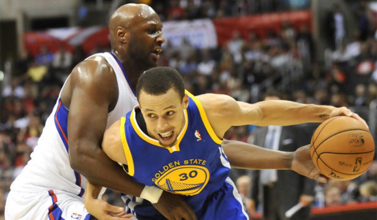 Lamar Odom, left, defends Golden State's Stephen Curry, who scored 23 points in the Warriors' 114-110 victory over the Clippers at Staples Center on Saturday night.