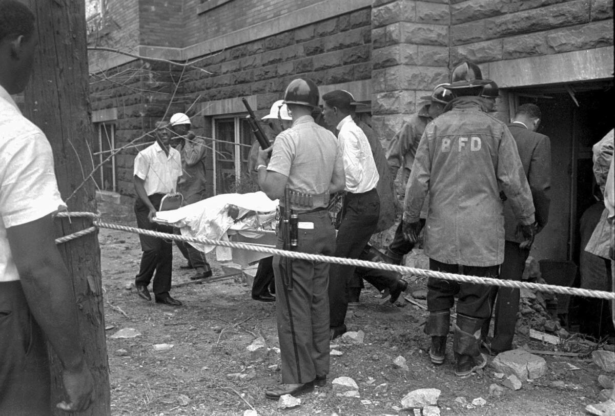 Firefighters and ambulance attendants remove a covered body from the 16th Street Baptist Church.