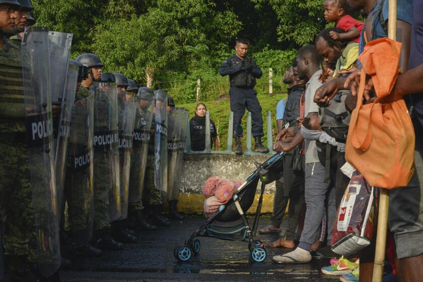 Migrants confront members of the National Guard near Tuzantan, Chiapas state, Mexico, Saturday, Oct. 12, 2019. Hundreds of migrants were arrested by Mexican authorities as they made their way to Mexico City. (AP Photo/Isabel Mateos)