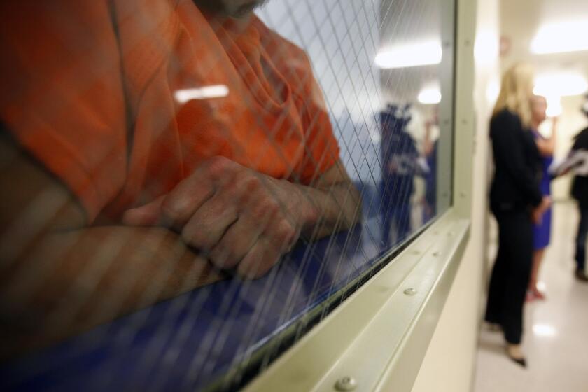 A detainee looks out from a holding area at the new immigrant detention center in Bakersfield.