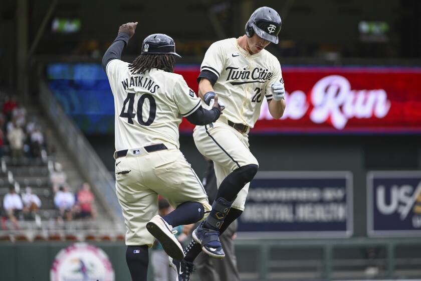 Minnesota Twins' Max Kepler, right, celebrates with third base coach Tommy Watkins as he rounds the bases after hitting a home run against the Seattle Mariners in the seventh inning of a baseball game, Thursday, May 9, 2024, in Minneapolis. The Twins won 11-1. (AP Photo/Craig Lassig)